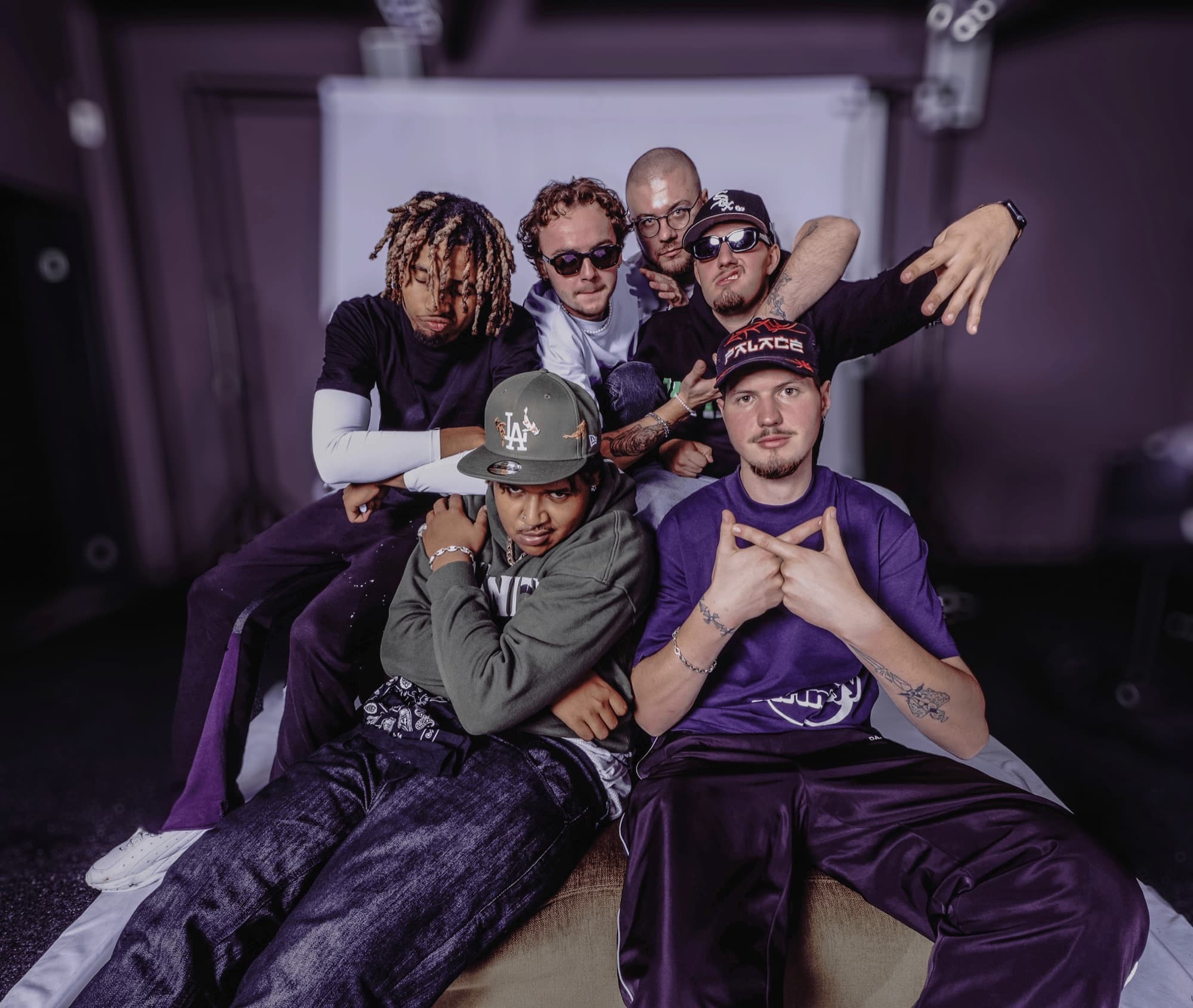 The collective together in the studio, lit in purple